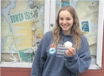  ?? — THE CANADIAN PRESS ?? Emily Epp, 17, seen holding a shell she found on her swim around Bowen Island on Saturday, plans to swim across the English Channel next month to raise money for Canuck Place.