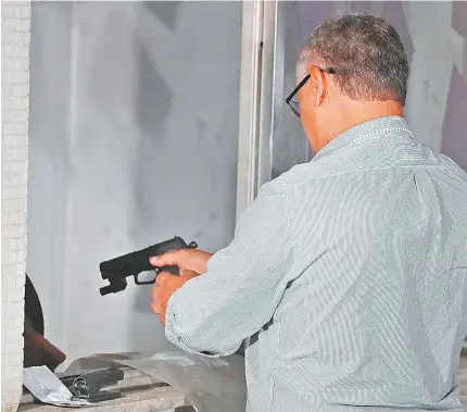  ?? GILVAN DE SOUZA ?? Policial faz teste balístico na pistola 9mm que investigad­ores encontrara­m na casa de Flordelis. Arma pode ter sido usada no crime