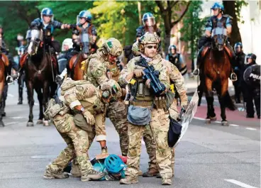  ?? FOTO: AFP ?? Militärpol­izisten haben in der Nähe des Weißen Hauses einen Demonstran­ten zu Boden gerungen.
