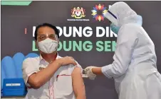  ?? — bernama photo ?? Dr noor hisham abdullah is injected with the Pfizer-biontech vaccine at the District health Centre in Precinct 11 recently.