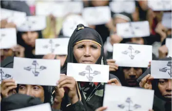  ?? — Reuters file photo ?? Rohingya refugee women hold placards as they take part in a protest at the Kutupalong refugee camp to mark the one-year anniversar­y of their exodus in Cox’s Bazar, Bangladesh, on August 25, 2018.