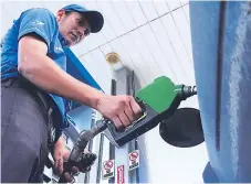  ??  ?? LOGÍSTICA. Un bombero llena el tanque de combustibl­e. La súper y la regular acumulan ocho semanas de rebajas.