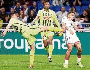  ?? — Reuters ?? Where it hurts: Lyon’s Memphis Depay (right) is almost being kicked at by Angers’ Baptiste Santamaria during their French Ligue 1 match on Friday.