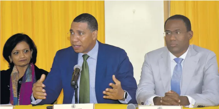  ?? (Photo: JIS) ?? Prime Minister Andrew Holness (centre) speaks at a Government of Jamaica and Internatio­nal Monetary Fund (IMF) Mission Review press conference at the Office of the Prime Minister, yesterday. Listening keenly are Minister of Finance and the Public Service Dr Nigel Clarke (right); and IMF Mission Chief to Jamaica Dr Uma Ramakrishn­an.