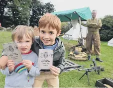  ??  ?? Brothers Abe and Zachary Guthrie, two and seven, with their ID cards.