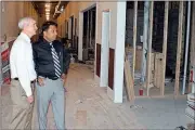  ??  ?? ABOVE: Hardy Realty CEO Jimmy Byars (left) and Dr. Raj Miniyar look at the progress being made on one of the first internatio­nal food court spaces in Miniyar’s mixed-use residentia­l/restaurant building.