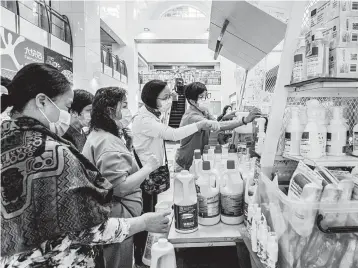  ?? LAM YIK FEI/THE NEW YORK TIMES ?? Evidence that deep cleaning lessens the threat of the virus indoors is scarce. Above, people buy cleaner in Hong Kong.