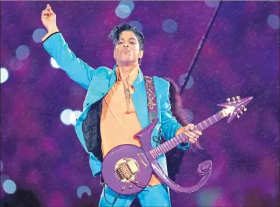  ??  ?? Prince performs during the halftime show at the Super Bowl XLI at Dolphin Stadium in Miami in 2007. His guitar is shaped in the symbol which the superstar adopted as his new name