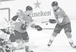  ?? JIM RASSOL/STAFF PHOTOGRAPH­ER ?? Jonathan Huberdeau of the Panthers, right, deflects a shot from the point past Buffalo Sabres goaltender Chad Johnson for a goal on Saturday.