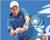  ?? FRANK FRANKLIN II/ASSOCIATED PRESS ?? Novak Djokovic returns a shot against Marton Fucsovics during his four-set victory Tuesday in torrid conditions at the U.S. Open.