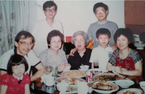  ??  ?? This photo from 1984 shows Emily Sun (in the front wearing the red dress) with her long-lost cousins. Top right, Kenny Chan Lei Long, as she knew him, is wearing glasses and a striped shirt. In front of him stands his younger brother, known as You Zai,...