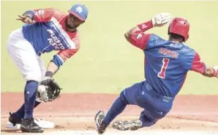  ?? AP ?? Roel Santos, tercer bate de Cuba, intenta estafarse la segunda base mientras Irving Falú, de Puerto Rico, aguarda por el disparo.