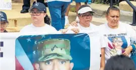  ??  ?? Chrys Carvajal’s sister Jennifer Ramirez, left, and mother, Lourdes Lara, hold a banner with Carvajal’s photo.