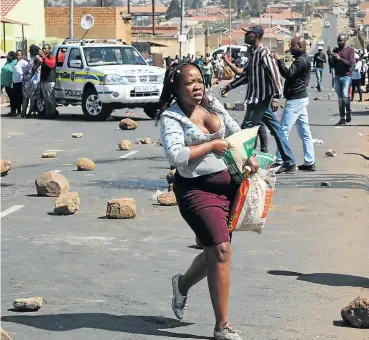  ?? Picture: Thulani Mbele ?? Residents of Jabavu in Soweto loot a foreign-owned tuck shop after Banele Qhayiso was shot dead, allegedly by a foreigner. Several residents had gone to loot the shop after reports that foreigners were selling ‘fake food’.