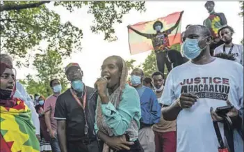  ??  ?? Solidarity: Protesters in Minnesota hold an Oromo flag (left) while singer Mawardi Moussa (right) addresses people protesting Hachalu Hundessa’s death. Photos: Stephen Maturen/getty/afp