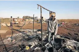  ??  ?? Dalson Chipu stands over his burned shack after the Ekurhuleni Metro Police allegedly torched it.