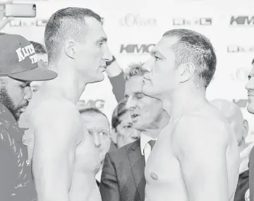  ?? — AFP photo ?? Ukrainian boxer Die Vladimir Klitschko (L) faces Bulgaria’s Kubrat Pulev at the weighing on November 14, 2014 in Hamburg on the eve of their heavyweigh­t boxing title fight.