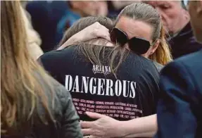  ??  ?? A woman hugging a girl wearing a T-shirt from Ariana Grande’s Dangerous Woman concert in Albert Square yesterday.