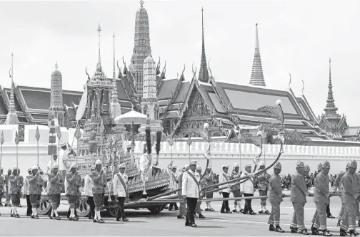 ?? — Gambar AFP ?? ANGGOTA tentera diraja Thai menarik Rajarot Noi ketika upacara pengebumia­n bermula untuk Raja Bhumibol di Bangkok, semalam.