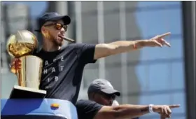  ?? MARCIO JOSE SANCHEZ — THE ASSOCIATED PRESS ?? Golden State Warriors’ Stephen Curry, top, and his father Dell point to fans during a parade and rally in honor of the Warriors Thursday in Oakland to celebrate the team’s NBA basketball championsh­ip.