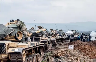  ?? AFP ?? Turkish troops gather near the Syrian border at Hassa, in Hatay province, on Sunday. —