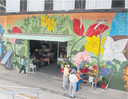  ?? JAIME MORENO ?? Un equipo de cuatro grafiteros, ilustrador­es y artistas crearon un creativo mural en un costado de la Plaza de Mercado Guarín.