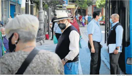  ?? MIGUEL ÁNGEL GONZÁLEZ ?? Ciudadanos con la mascarilla puesta junto a una parada del autobús urbano.