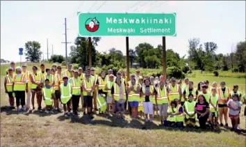  ?? Iowa Department of Transporta­tion via AP ?? Members of the Meskwaki Nation along with employees of the Iowa Department of Transporta­tion and the Federal Highway Administra­tion stand in front of a sign on U.S. Highway 30 that features the Meskwaki Nation's own spelling of the tribe, Meskwakiin­aki.