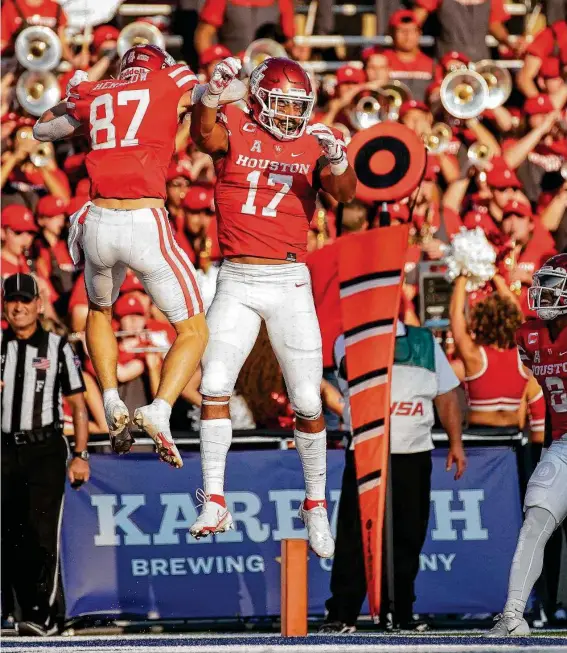  ?? Godofredo A. Vásquez / Staff photograph­er ?? UH wide receiver Jake Herslow celebrates with tight end Seth Green after scoring on an 11-yard touchdown pass from quarterbac­k Clayton Tune in the first quarter.