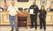  ?? / Kevin Myrick ?? Sgt. Michael Evans (center) was provided with a commendati­on for his swift and calm actions in helping a child injured by a lawnmower in recent days. Joining Evans was Mayor Garry Baldwin and Interim Chief Allison Taulbee.