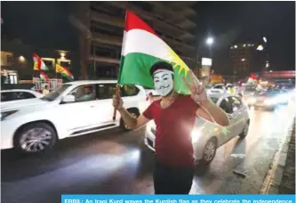  ??  ?? ERBIL: An Iraqi Kurd waves the Kurdish flag as they celebrate the independen­ce referendum in the streets of the northern city of Erbil. —AFP