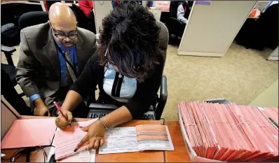  ?? AP/MIKE STEWART ?? A Fulton County, Ga., election worker counts provisiona­l ballots Wednesday in Atlanta.