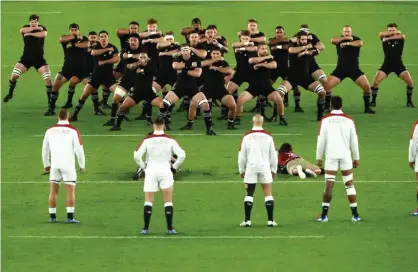 ??  ?? England players look on while New Zealand players perform a haka. Photograph: Francois Nel/World Rugby via Getty Images