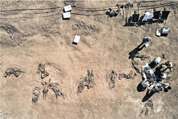  ??  ?? An aerial view of the remains of unearthed bodies, reportedly from the Badush prison massacre carried out by the Islamic State in Iraq in 2014