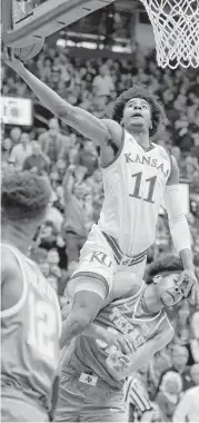  ?? Charlie Riedel / Associated Press ?? Kansas’ Josh Jackson soars over Texas’ Jarrett Allen to put up a shot during the first half, helping the Jayhawks jump out to a 41-33 lead at the break.