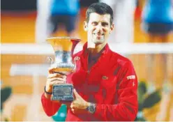  ?? Reuters ?? ↑
Novak Djokovic celebrates with the trophy after winning the Italian Open final against Diego Schwartzma­n (unseen) in Rome on Monday.