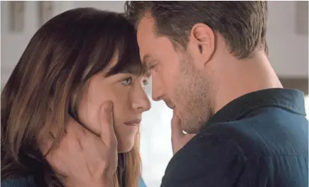  ??  ?? Dakota Johnson is lip-biting ingénue Anastasia Steele and Jamie Dornan is sexy-but-damaged billionair­e Christian Grey in the “Fifty Shades” movie trilogy. DOANE GREGORY, UNIVERSAL PICTURES