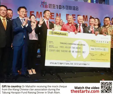  ??  ?? Gift to country: Dr Mahathir receiving the mock cheque from the Klang Chinese clan associatio­n during the Tabung Harapan Fund Raising Dinner in Shah Alam.