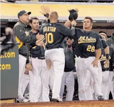  ?? Carlos Avila Gonzalez / The Chronicle ?? Daric Barton is warmly received after scoring the game’s first run on Kurt Suzuki’s double in the eighth inning.