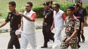  ?? PIC BY MOHD FADLI HAMZAH ?? N. Pathmanabh­an (behind) and T. Thilaiyala­gan being taken away after the court upheld their conviction and sentence at the Federal Court in Putrajaya yesterday.