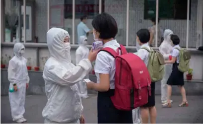  ?? AFP/VNA Photo ?? Students of the Pyongyang Jang Chol Gu University of Commerce undergo temperatur­e checks before entering the campus as part of preventive measures against COVID-19 in Pyongyang.