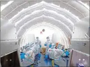  ?? PTI ?? In this photo released by Xinhua News Agency, staff members work in an inflatable COVID-19 testing lab in Beijing