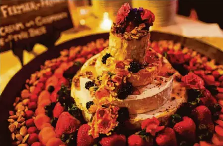  ?? Provided by Jess Lander ?? Reporter Jess Lander's wedding cake was a tower of cheese decorated with honey, flowers, fruits and nuts.