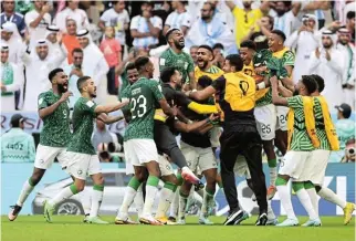  ?? /Reuters ?? Mob joy: Saudi Arabia players and reserves celebrate Salem Al-Dawsari’s winning goal against Argentina on Tuesday.