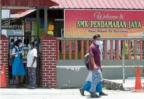  ?? — KK SHAM/The Star ?? Taking no chances: Some parents were seen taking their children home after reports that two students were confirmed to be infected with Covid-19 at SMK Pendamaran Jaya in Port Klang.