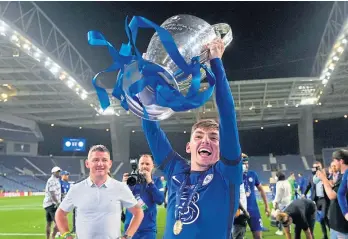  ??  ?? BLUES BROTHER: Chelsea’s Billy Gilmour with the Champions League trophy and top, during a Scotland training session at Rockliffe Park, Darlington.