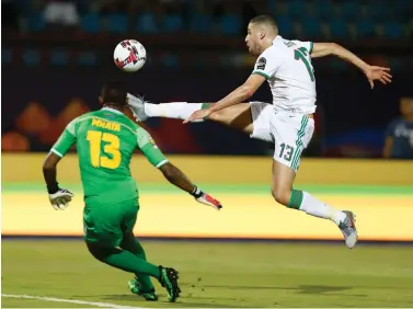  ?? Ariel Schalit/Associated Press ?? ■ Algeria’s Islam Slimani, right, shoots by his opponent during the African Cup of Nations group C soccer match between Tanzania and Algeria on July 1 in Al Salam Stadium in Cairo.