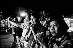  ?? LAUREN DECICCA/GETTY ?? Onlookers cheer as ambulances deliver four boys rescued from a cave in northern Thailand to a hospital in Chiang Rai.