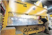  ?? JASON BAIN EXAMINER ?? Quickmill service technician Mike Morrissey operates the Intimidato­r as part of a demonstrat­ion for guests as the Rye Street company celebrated the 100th build/sale of the large machining centre on Monday.