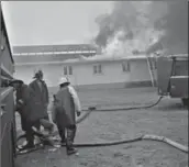  ?? UNIVERSITY OF WATERLOO LIBRARY SPECIAL COLLECTION­S & ARCHIVES, KITCHENER-WATERLOO RECORD PHOTOGRAPH­IC NEGATIVE COLLECTION ?? Left, with no water mains to connect to, firefighte­rs from the Waterloo Township, New Dundee and Galt fire department­s were frustrated in their attempts to save Rosslynn Grove on April 27, 1964.